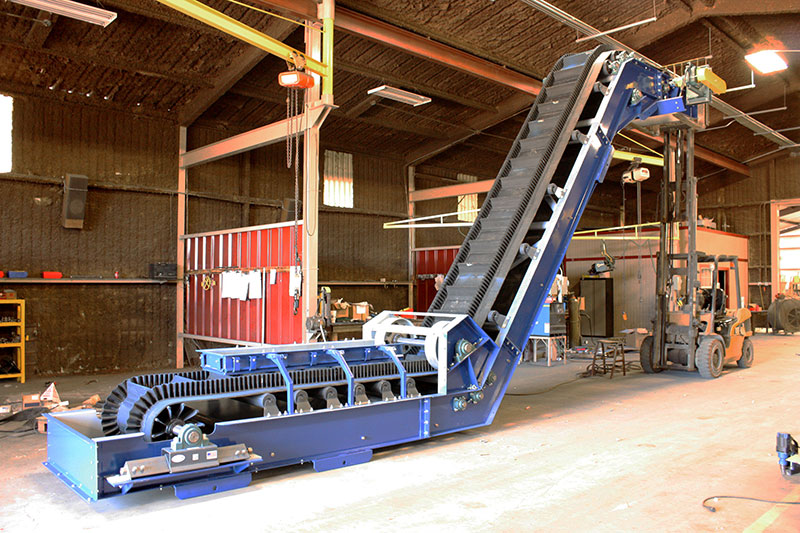 Cleated sidewall conveyors on warehouse floor - Kase Conveyors
